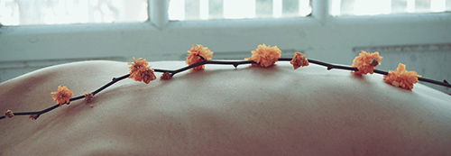Schiena con fiori arancioni lungo la colonna vertebrale